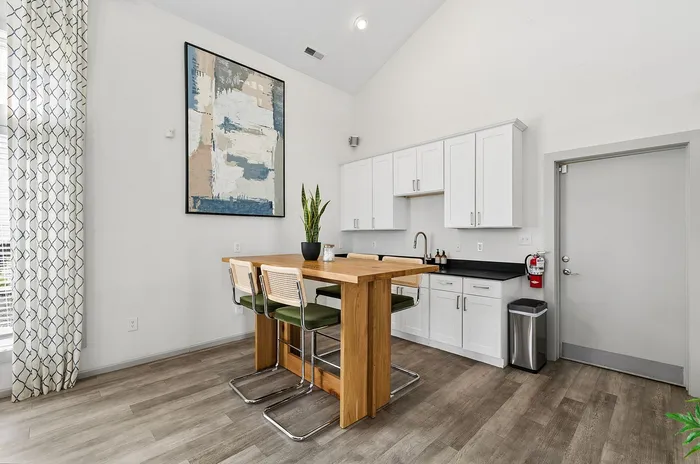 Bright, contemporary kitchen with sleek white cabinetry, a stylish wooden island, and elegant decor.