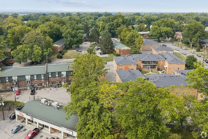 Charming apartment complex nestled in lush greenery with ample parking and inviting courtyards.