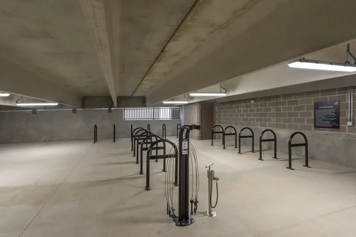 Spacious bicycle parking area with secure racks and modern lighting in an apartment complex.