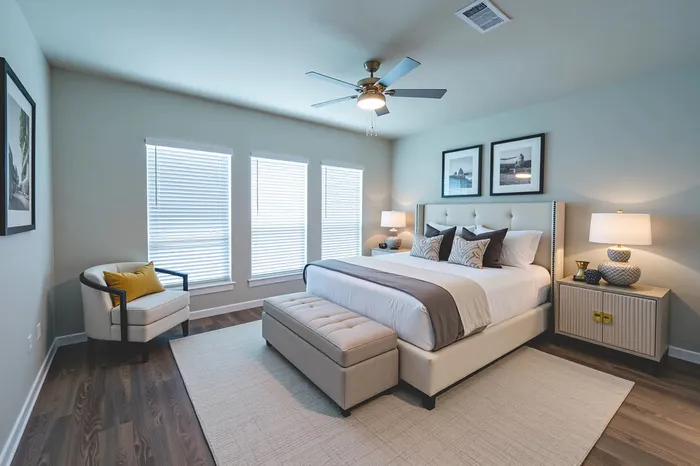 Elegant bedroom with a plush king-size bed, modern decor, and large windows offering natural light.