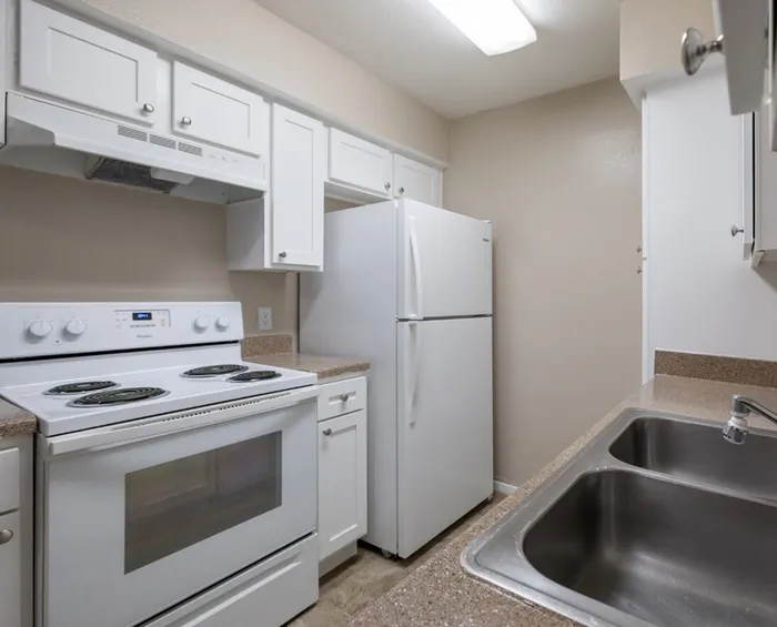 Contemporary kitchen with sleek white cabinetry, premium appliances, and ample counter space, creating a bright and inviting cooking area.
