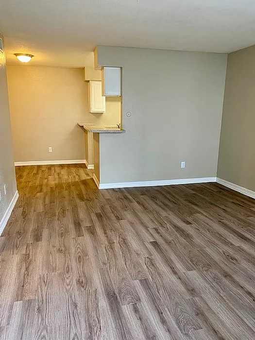 Charming apartment interior with elegant wood flooring, open layout, and cozy breakfast bar, perfect for modern living.