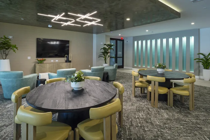 Chic community lounge featuring modern lighting, plush seating, and elegant decor, perfect for relaxation and social gatherings.