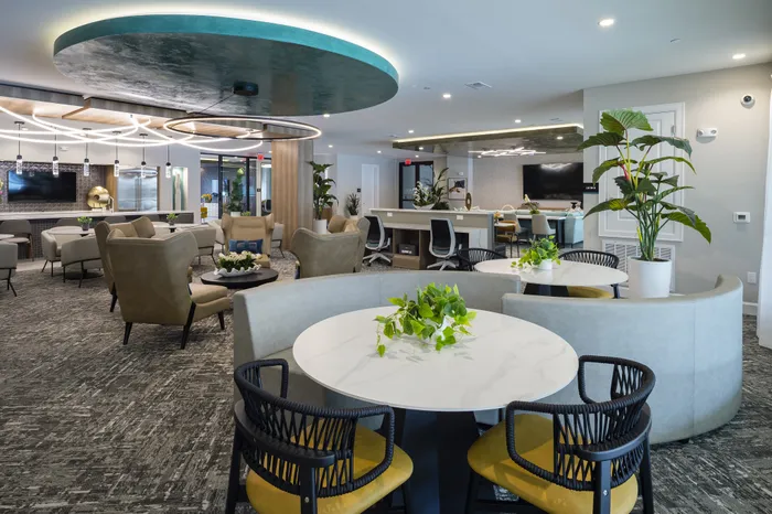 Luxurious modern lounge with elegant seating, stylish lighting, and lush greenery, perfect for relaxation and social gatherings.