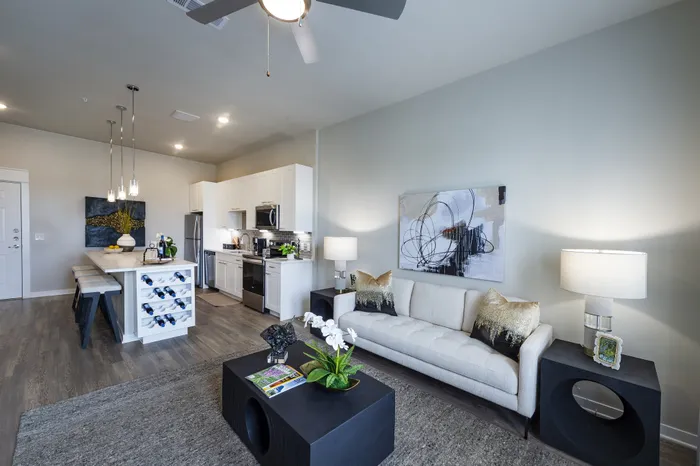 Contemporary open-concept living room and kitchen with sleek decor, modern appliances, and elegant lighting.