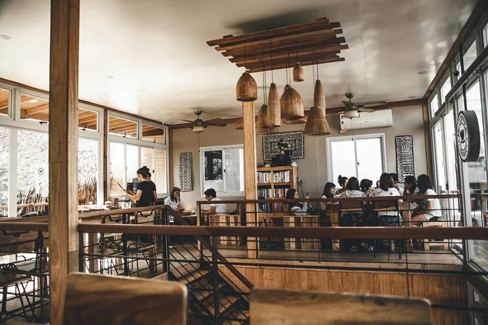 Charming cafe interior featuring rustic wooden decor, elegant pendant lighting, and a cozy atmosphere with patrons enjoying their time.