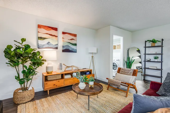 Inviting living room with vibrant artwork, cozy seating, and lush greenery, perfect for relaxation and entertaining.