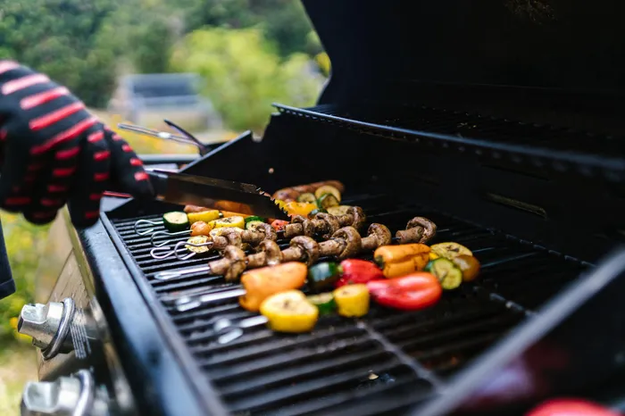 Vibrant outdoor grilling scene with colorful vegetables and mushrooms sizzling on the barbecue, perfect for backyard gatherings.
