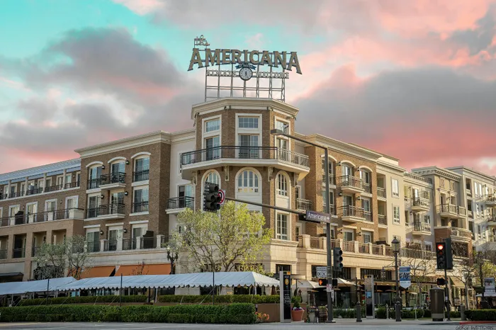 Charming urban apartment complex with elegant balconies and vibrant sunset backdrop at The Americana.