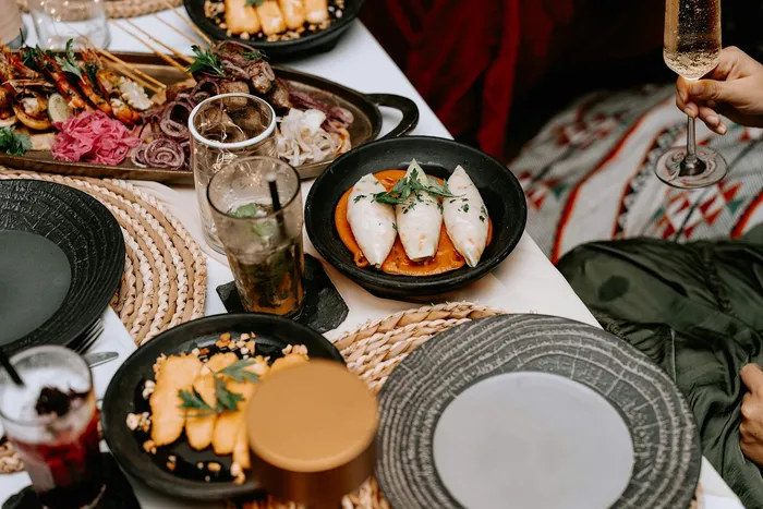 Elegant dining setup featuring assorted gourmet dishes, refreshing beverages, and a touch of luxury with sparkling wine.