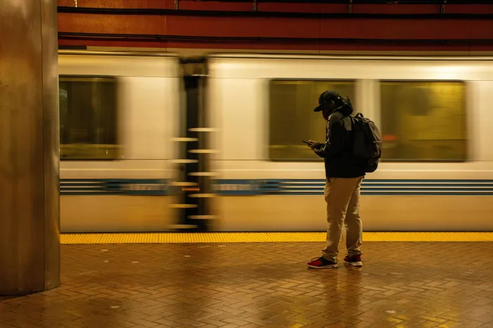 Dynamic subway scene with a commuter waiting on the platform as a train speeds by, capturing the essence of urban transit.