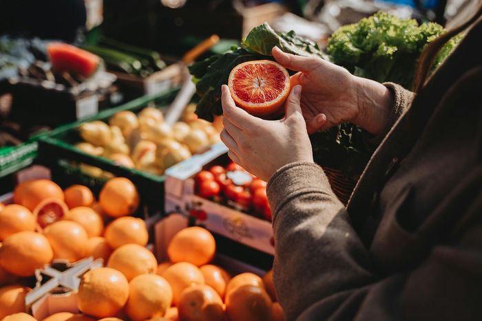 Vibrant display of fresh blood oranges at a bustling farmers market, showcasing natural, healthy produce.
