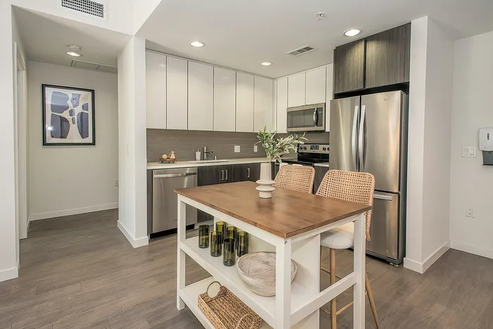Modern kitchen with sleek appliances and stylish cabinetry featuring a spacious island and elegant decor.