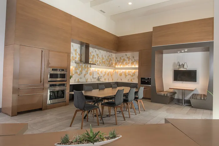 Contemporary kitchen with elegant wood finishes, featuring a large dining table, modern appliances, and a cozy breakfast nook.