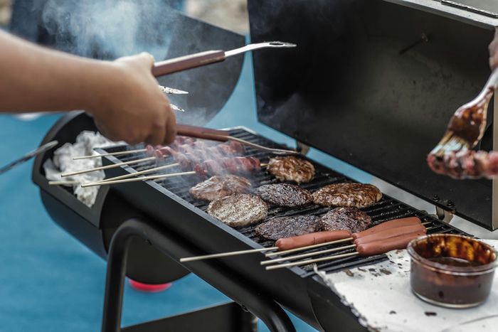 Grill loaded with burgers and hot dogs, representing outdoor BBQ gatherings at Twin Creeks.