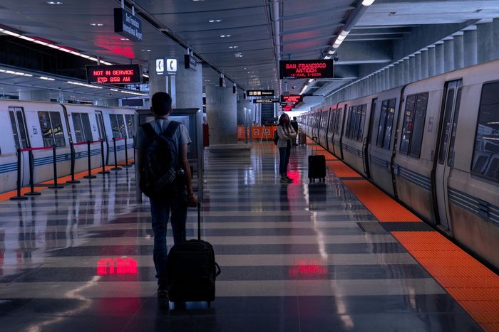 BART train station platform with passengers and luggage, representing Bay Area transit access near Twin Creeks.