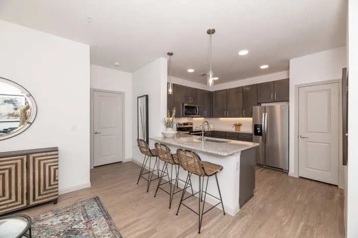 Modern kitchen with sleek cabinetry, stainless steel appliances, and a stylish breakfast bar with rattan seating.
