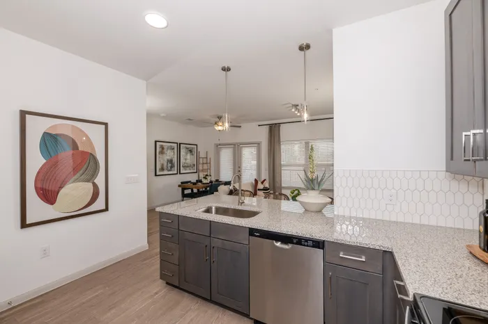 Modern apartment featuring a sleek kitchen with granite countertops, open living area, and stylish decor for a welcoming atmosphere.