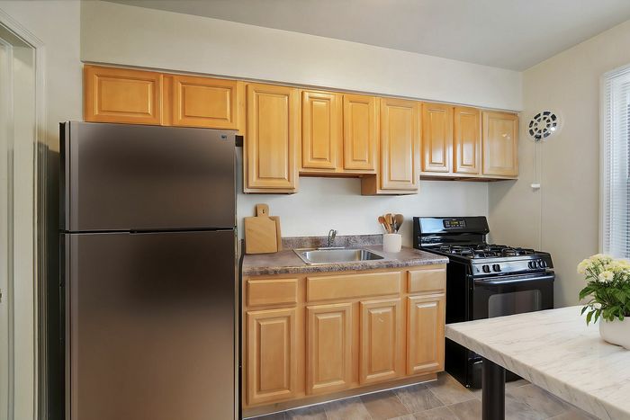 Modern kitchen with sleek stainless steel appliances, wooden cabinetry, and a granite countertop.