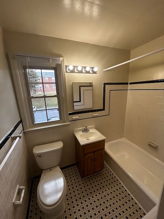 Cozy bathroom with elegant black and white tiles, a sleek vanity, and a bright window view.