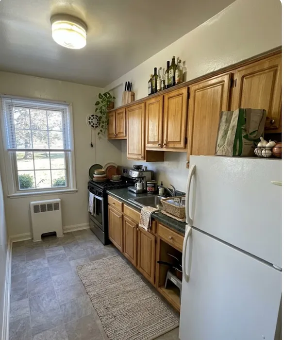 Charming kitchen with warm wooden cabinets, natural light, and modern appliances offering a cozy cooking experience.