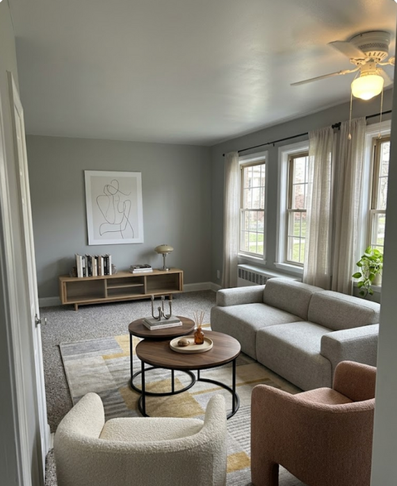 Bright and inviting living room with modern furniture, large windows, and stylish decor in a cozy apartment setting.