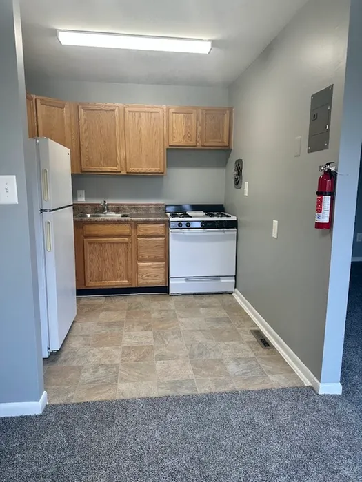 Cozy kitchen featuring wooden cabinets, a compact stove, and a modern tiled floor, perfect for a functional culinary space.