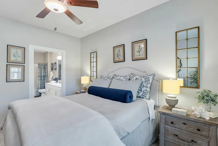 Inviting bedroom with elegant decor, featuring a plush bed, stylish lamps, and a glimpse of an ensuite bathroom, creating a cozy and modern living space.