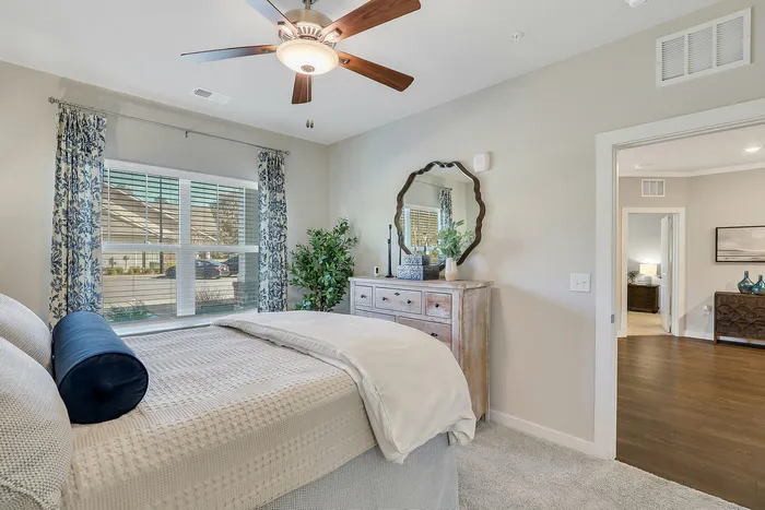 Bright and elegant bedroom featuring plush bedding, stylish decor, and a scenic window view, offering a serene and welcoming atmosphere.