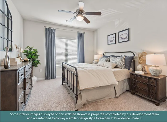 Elegant bedroom with soft lighting, a comfy bed with decorative pillows, stylish wooden furniture, and a ceiling fan for comfort.