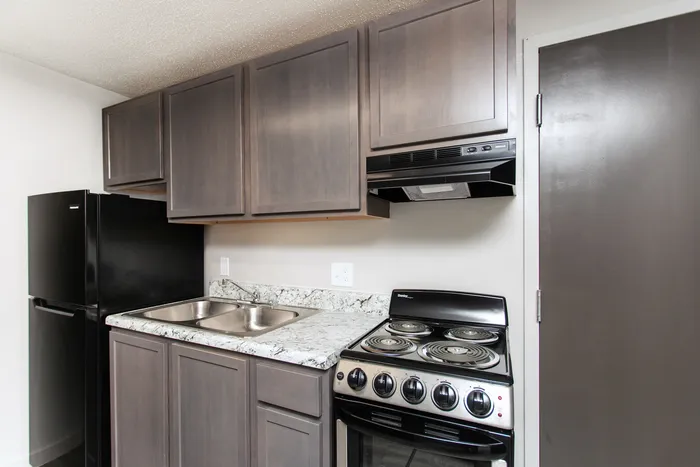 Modern kitchen with sleek granite countertops, elegant cabinetry, and bar seating, offering a perfect blend of style and functionality.