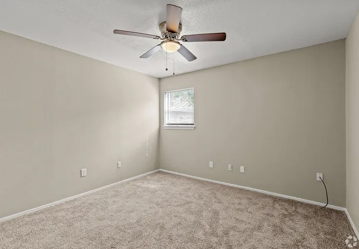 Cable-ready bedroom with a window and a ceiling fan at Fox Trail Apartments