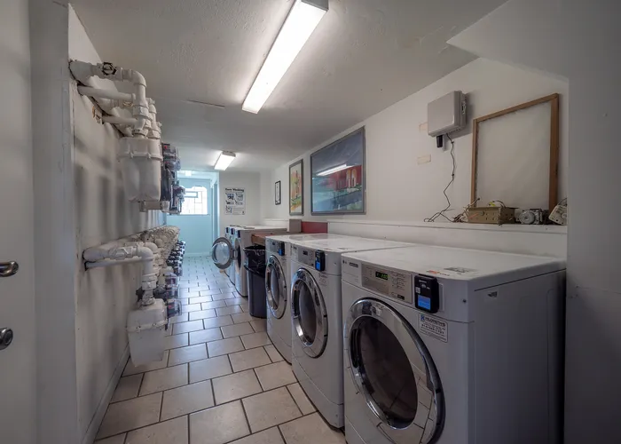 Bright and functional laundry room featuring modern washing machines and efficient lighting, perfect for convenient apartment living.