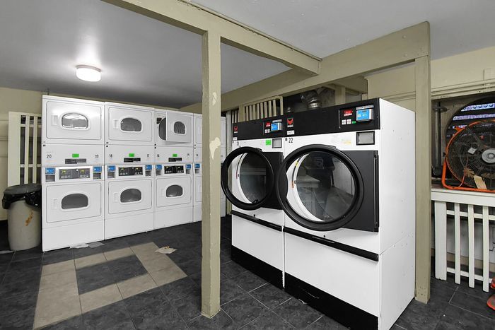Modern laundry room with multiple washers and dryers, offering convenience and efficiency in a well-lit and spacious area.