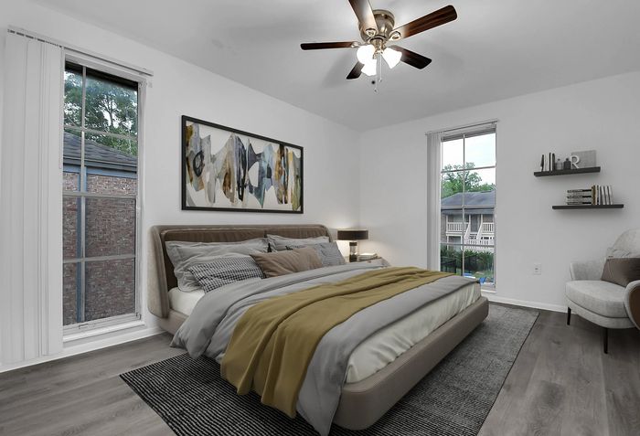 Modern bedroom with elegant decor, showcasing a cozy bed with stylish bedding, artistic wall art, sleek ceiling fan, and serene views from large windows.