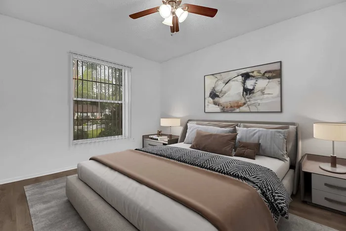 Serene bedroom with elegant decor, featuring a cozy bed, stylish artwork, and a scenic garden view through the window.