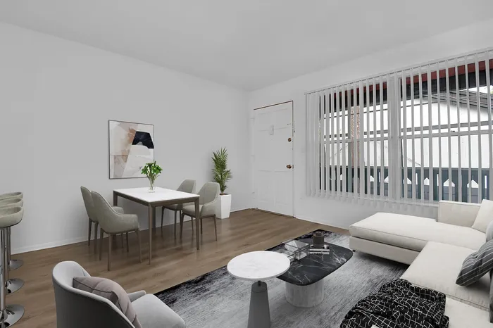 Contemporary living and dining area with stylish furniture, cozy seating, and large window for natural light.