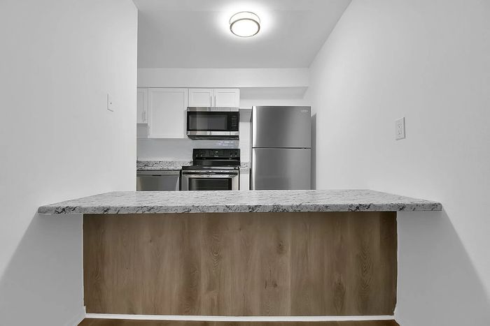 Modern kitchen space with sleek stainless steel appliances, elegant granite countertops, and minimalist design, perfect for culinary creativity.