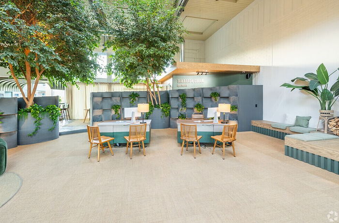 Inviting modern workspace featuring lush indoor greenery, stylish seating, and ample natural light.