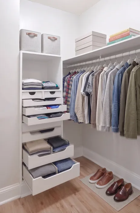 Elegant walk-in closet with neatly organized shelves and hanging space, showcasing a variety of stylish clothing and shoes.
