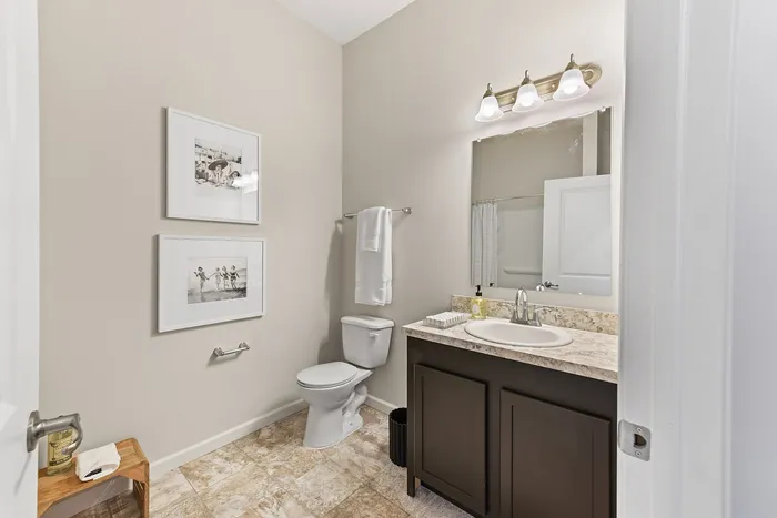 Elegant bathroom featuring modern fixtures, a marble countertop, and stylish wall art, offering a tranquil retreat.