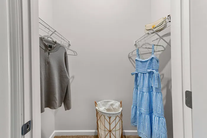 Chic modern closet with elegant shelving, featuring stylish clothing, perfect for organizing your wardrobe in a sophisticated apartment setting.