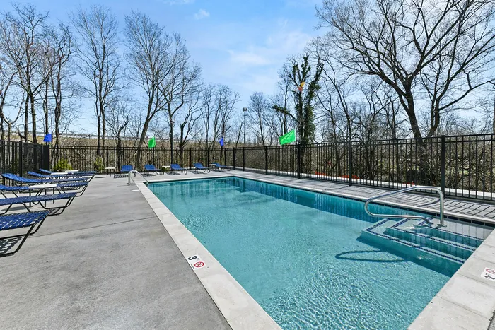Inviting outdoor swimming pool area surrounded by elegant loungers and scenic views, perfect for relaxation and leisure.