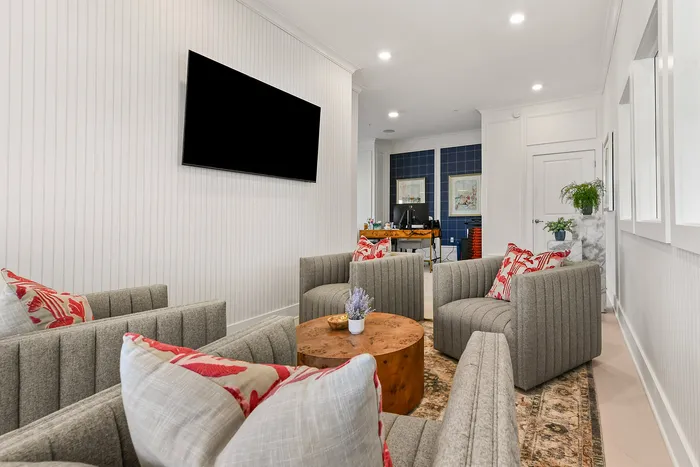 Inviting lounge area with modern gray armchairs, vibrant pillows, and a stylish wooden coffee table, perfect for relaxation.