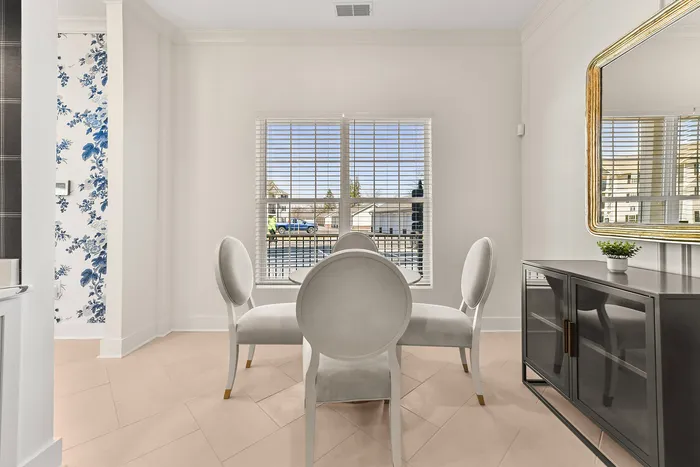Bright dining area with elegant chairs, large windows, and modern decor, offering a chic and inviting atmosphere.
