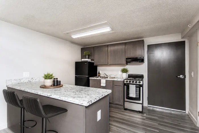 Modern kitchen with sleek granite countertops, elegant cabinetry, and bar seating, offering a perfect blend of style and functionality.