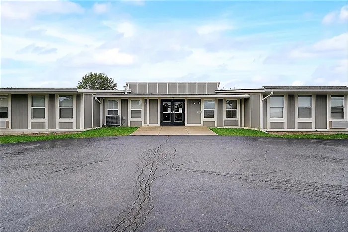 Contemporary single-story building with sleek design, large windows, and welcoming entrance.