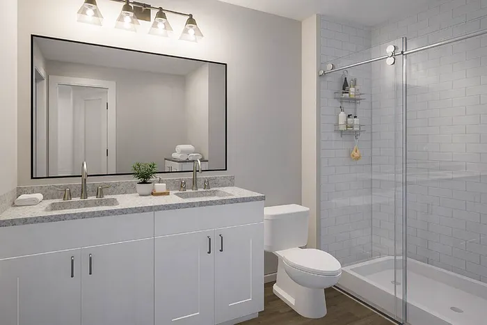 Elegant bathroom with a dual-sink vanity, modern light fixtures, and a sleek glass shower.