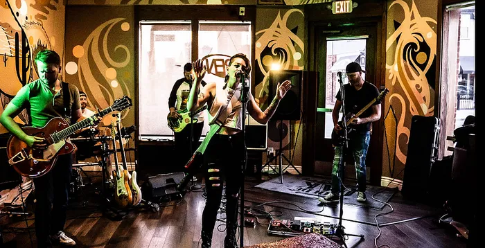 Energetic live band performance in a vibrant, art-filled venue with a dynamic singer and talented musicians.