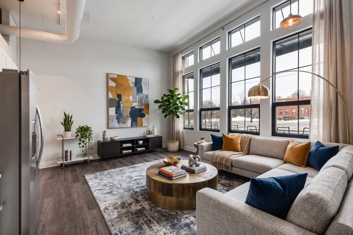 Bright and modern living room with tall windows, stylish decor, and plush seating, perfect for relaxation and entertaining.